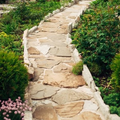 Stone walkway in garden made of big yellow stones, garden landscaping design.